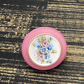 Circular cocktail ring with floral design on a textured black and gold background