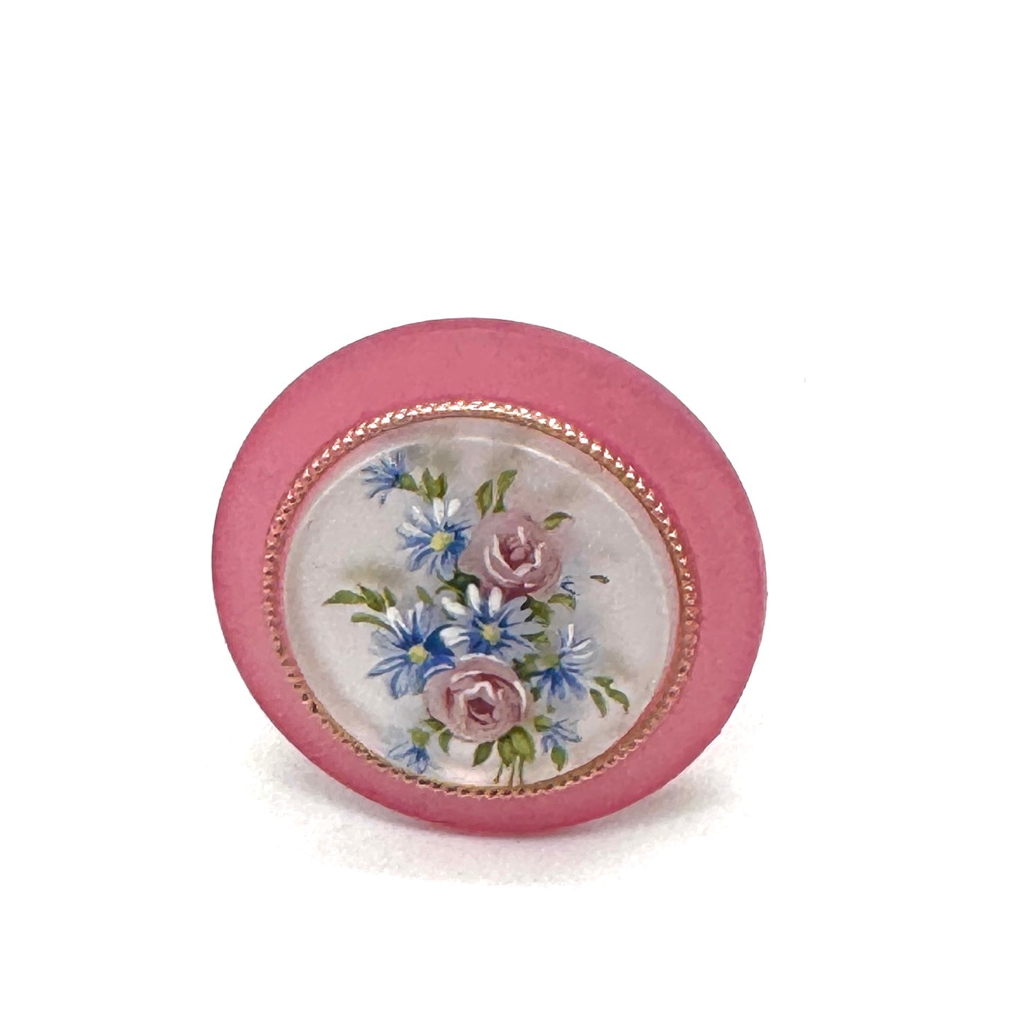 Circular cocktail ring with floral design on a white background.