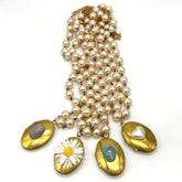 Pearl necklaces with gold locket pendants featuring on a white background