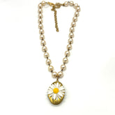 Pearl necklace with a daisy flower pendant on a white background