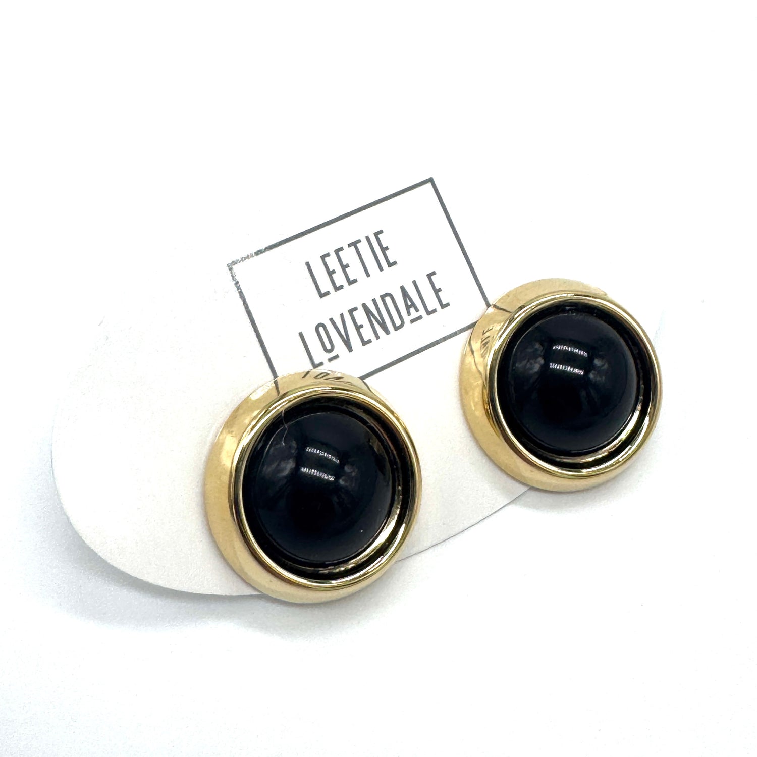 Black and gold earrings on a white background with &