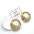 Pearl earrings with gold accents on a white background with &