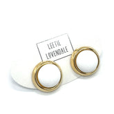 Gold and white stud earrings on a white card with &