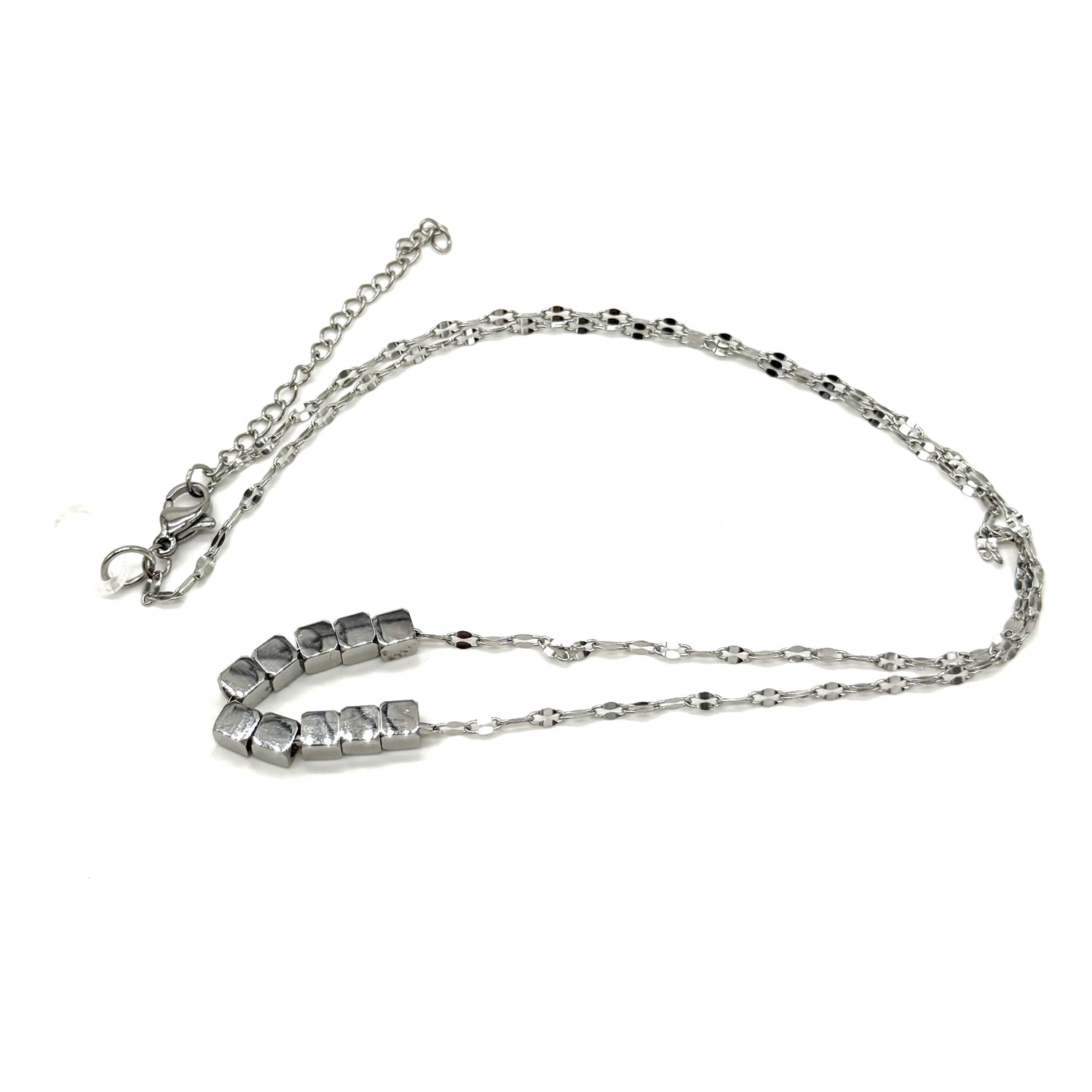 A silver necklace on a white background. It is a fine chain with several cube beads at the center.