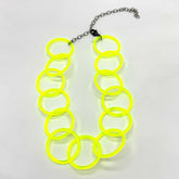Adjustable necklace featuring large lucite chain links in a neon yellow