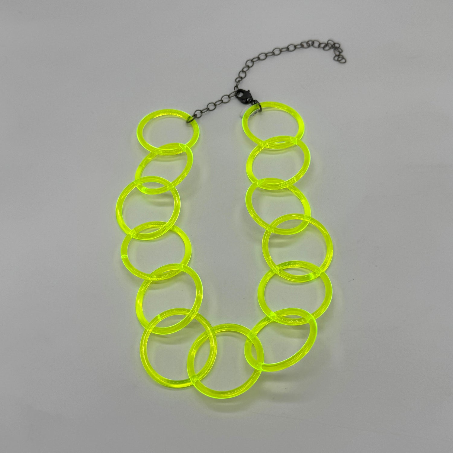 Adjustable necklace featuring large lucite chain links in a neon yellow