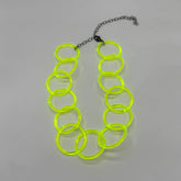 Adjustable necklace featuring large lucite chain links in a neon yellow