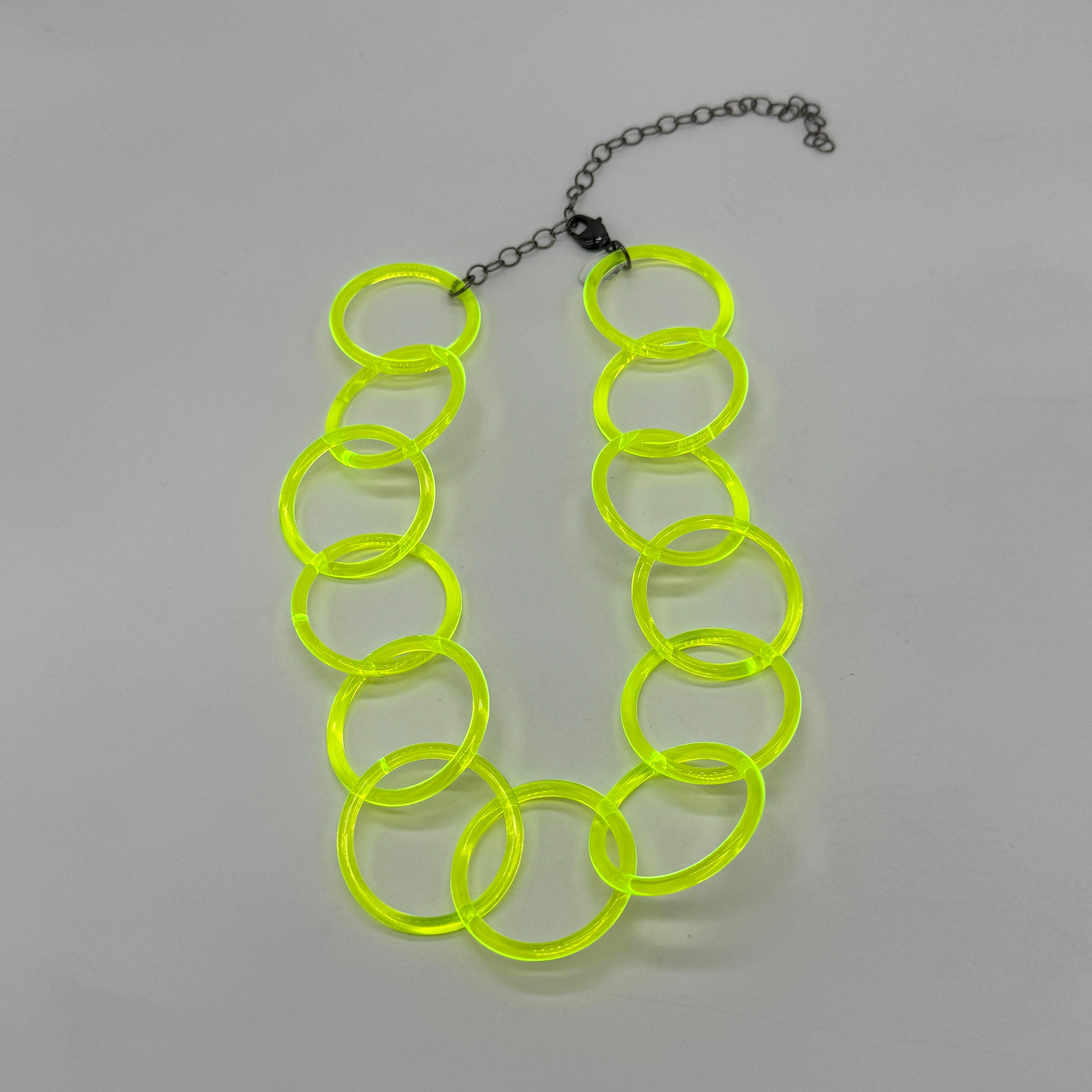Adjustable necklace featuring large lucite chain links in a neon yellow