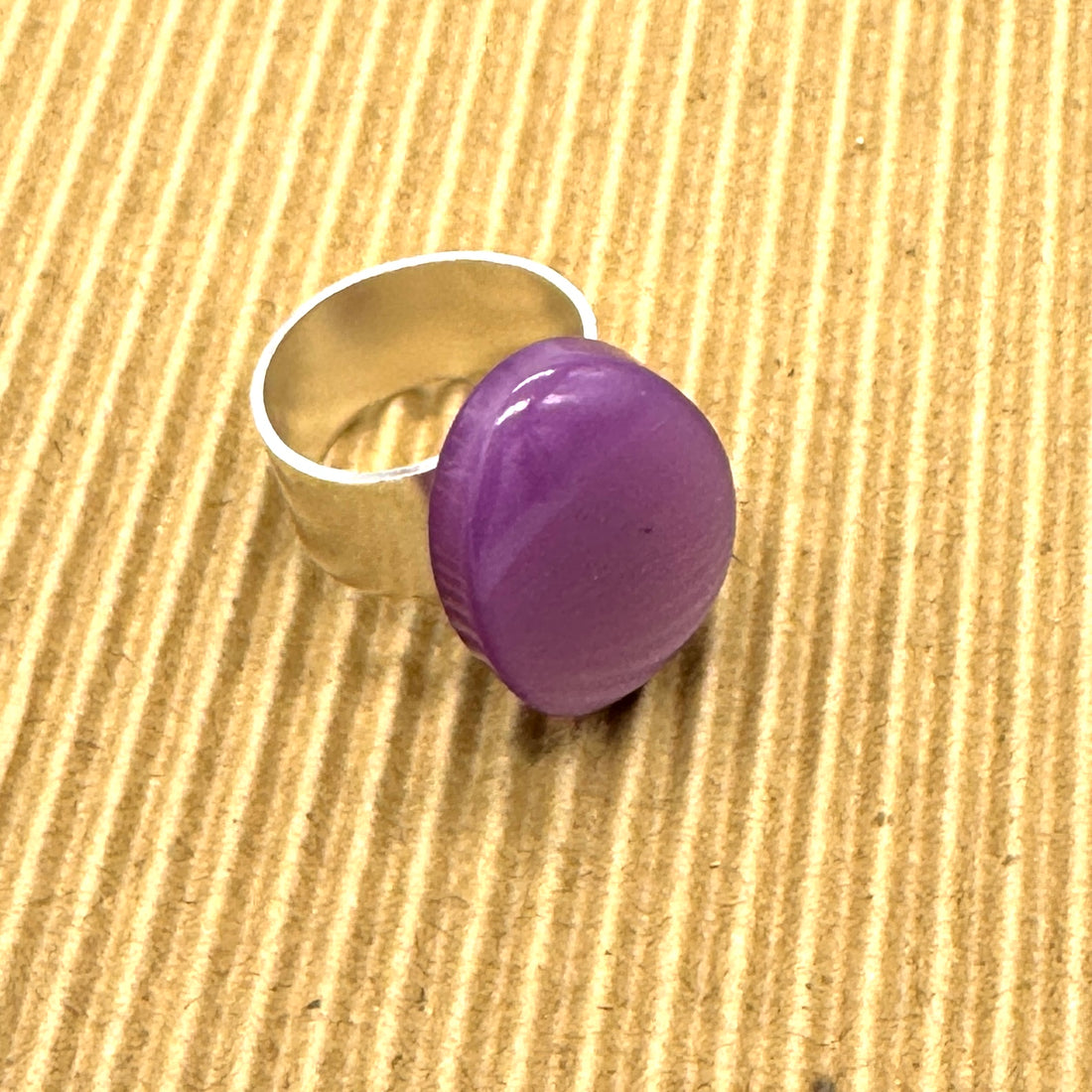 Cocktail ring featuring large purple moonglow focal on a brown textured background.