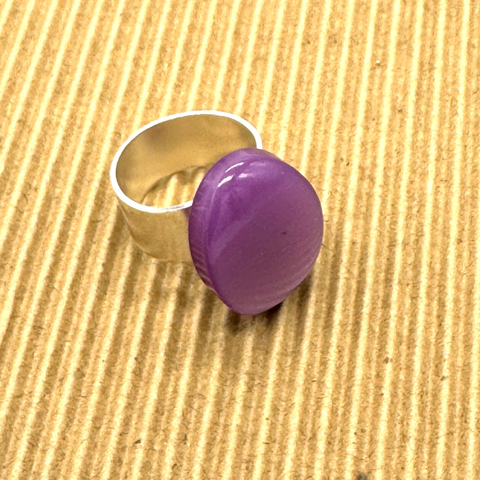Cocktail ring featuring large purple moonglow focal on a brown textured background.