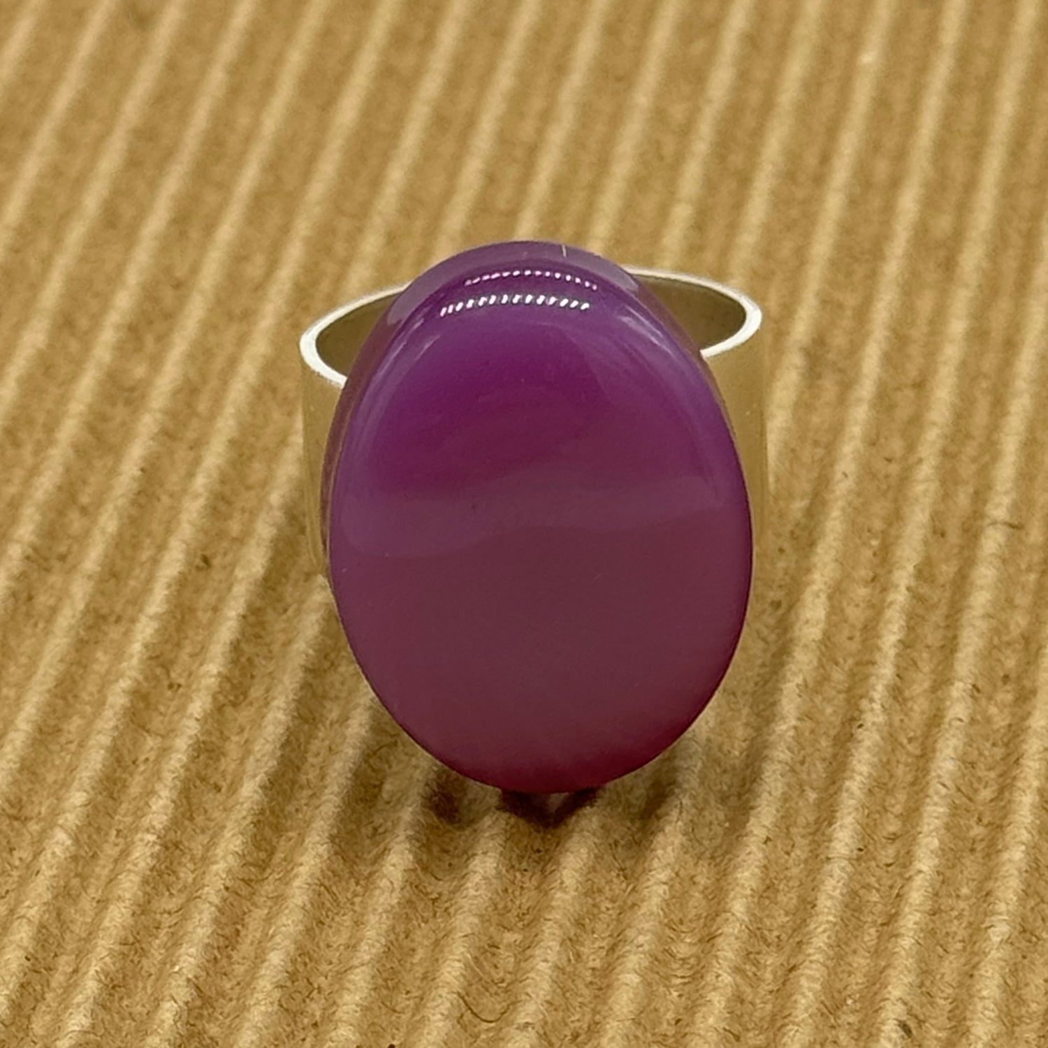 Cocktail ring featuring large purple moonglow focal on a brown textured background.