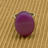 Cocktail ring featuring large purple moonglow focal on a brown textured background.