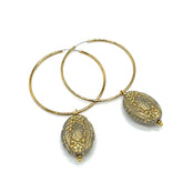 Hoop earrings with carved gray bead dangles with gold leaf.