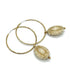 Hoop earrings with carved white bead dangles with gold leaf.