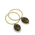 Hoop earrings with carved black bead dangles with gold leaf.