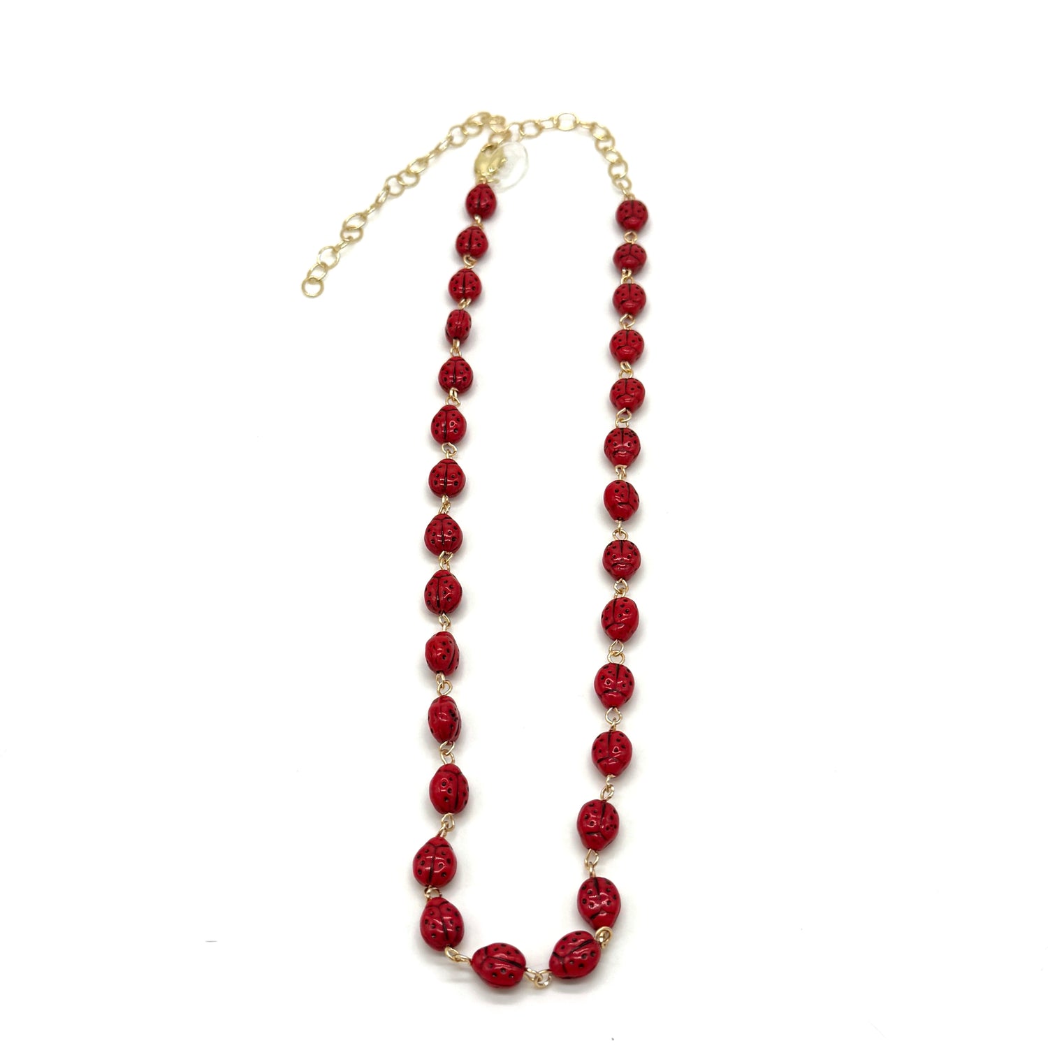 Red beaded necklace with gold chain on a white background