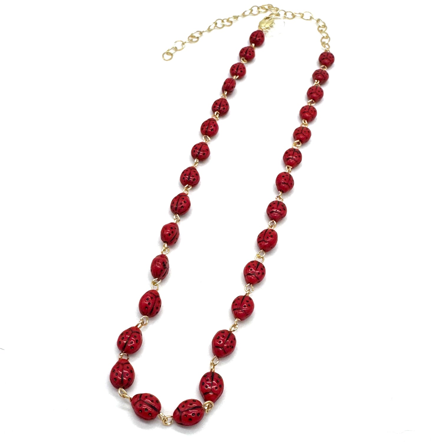 Red beaded necklace with gold chain on a white background