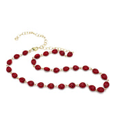 Necklace with red beads and gold chain on a white background