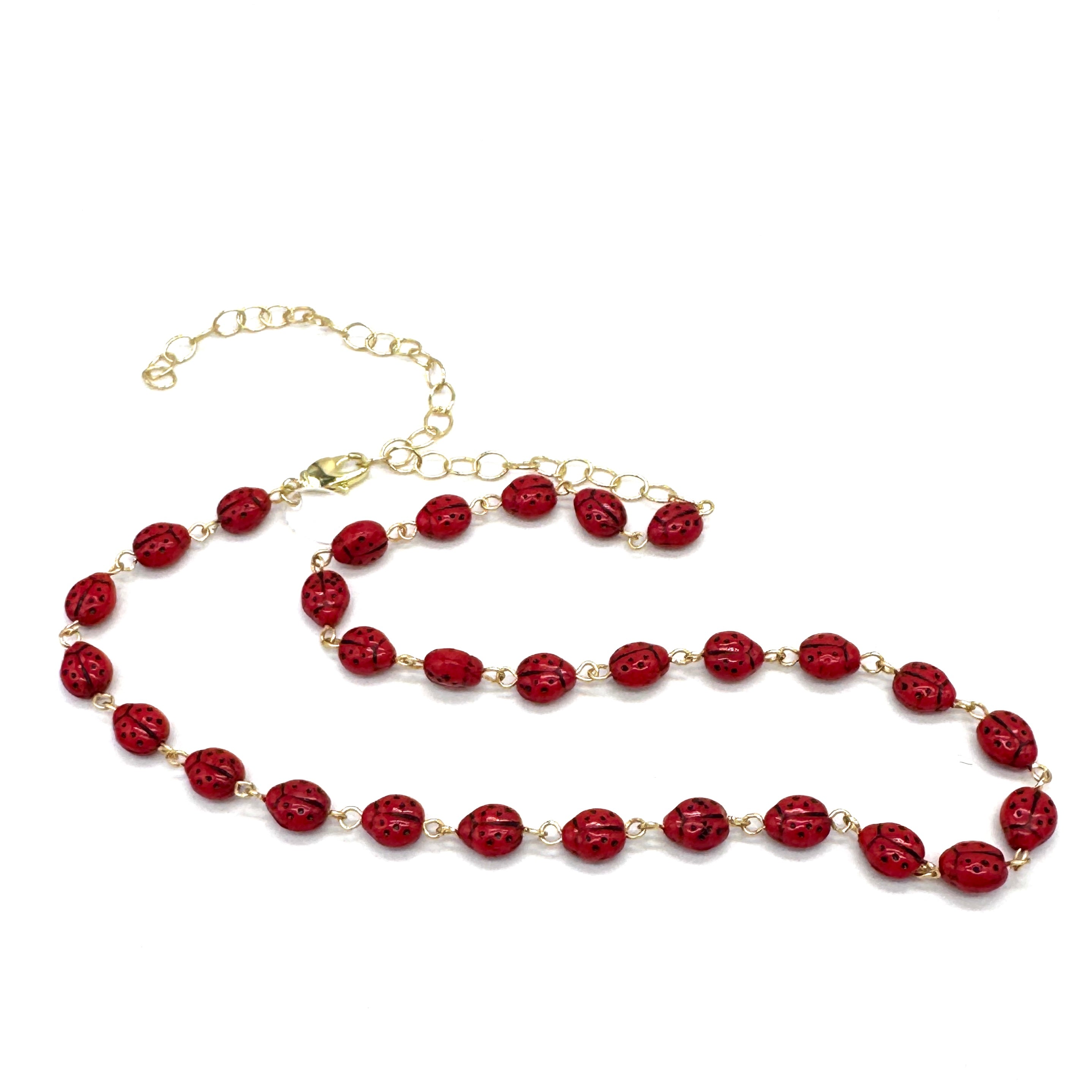 Necklace with red beads and gold chain on a white background