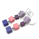 Colorful cube-shaped beaded earrings on a white background with &