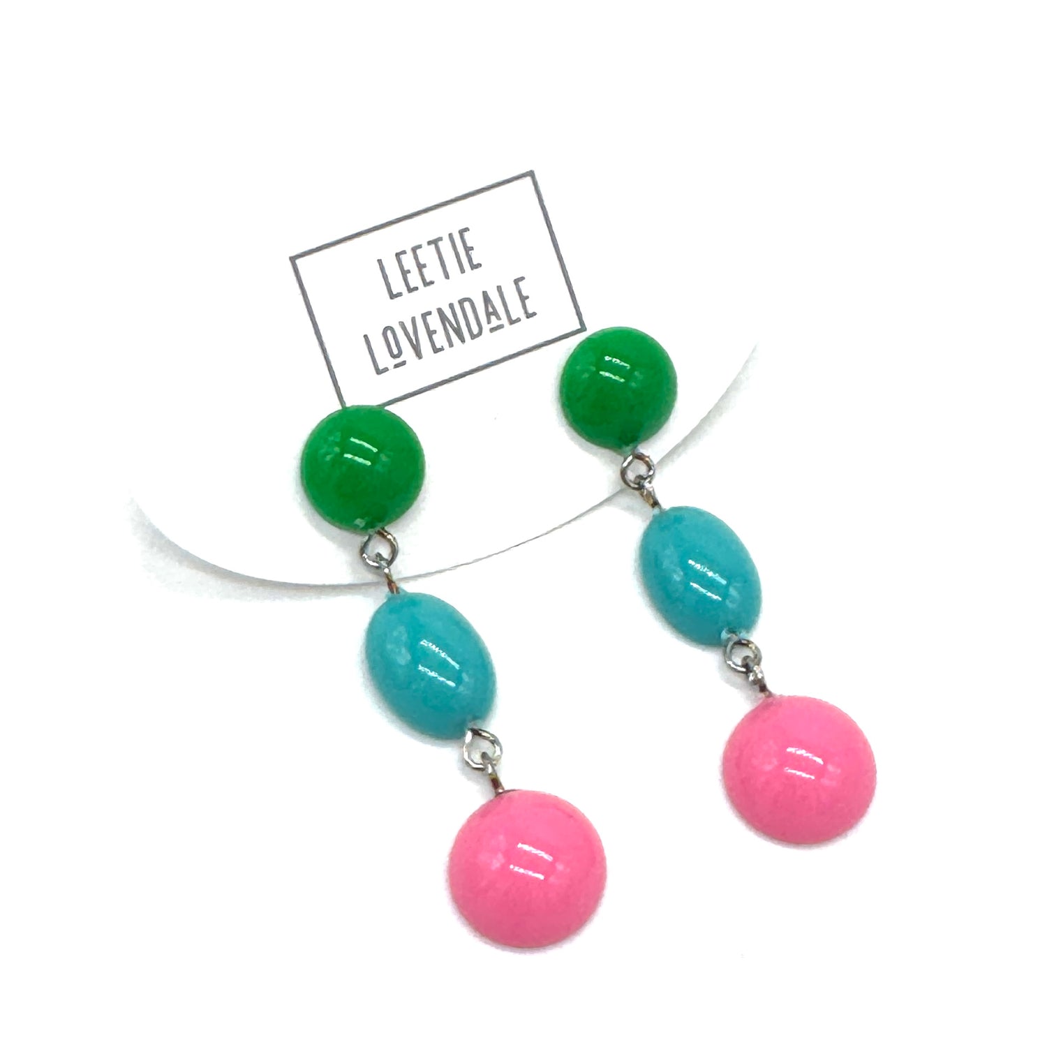 Earrings with green, blue, and pink beads on a white background with &