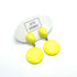 Yellow earrings on a white card with &