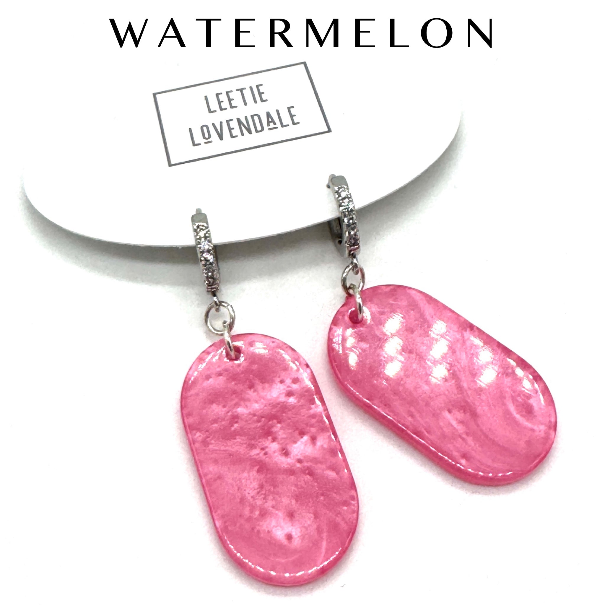 Pink earrings on a white background with &