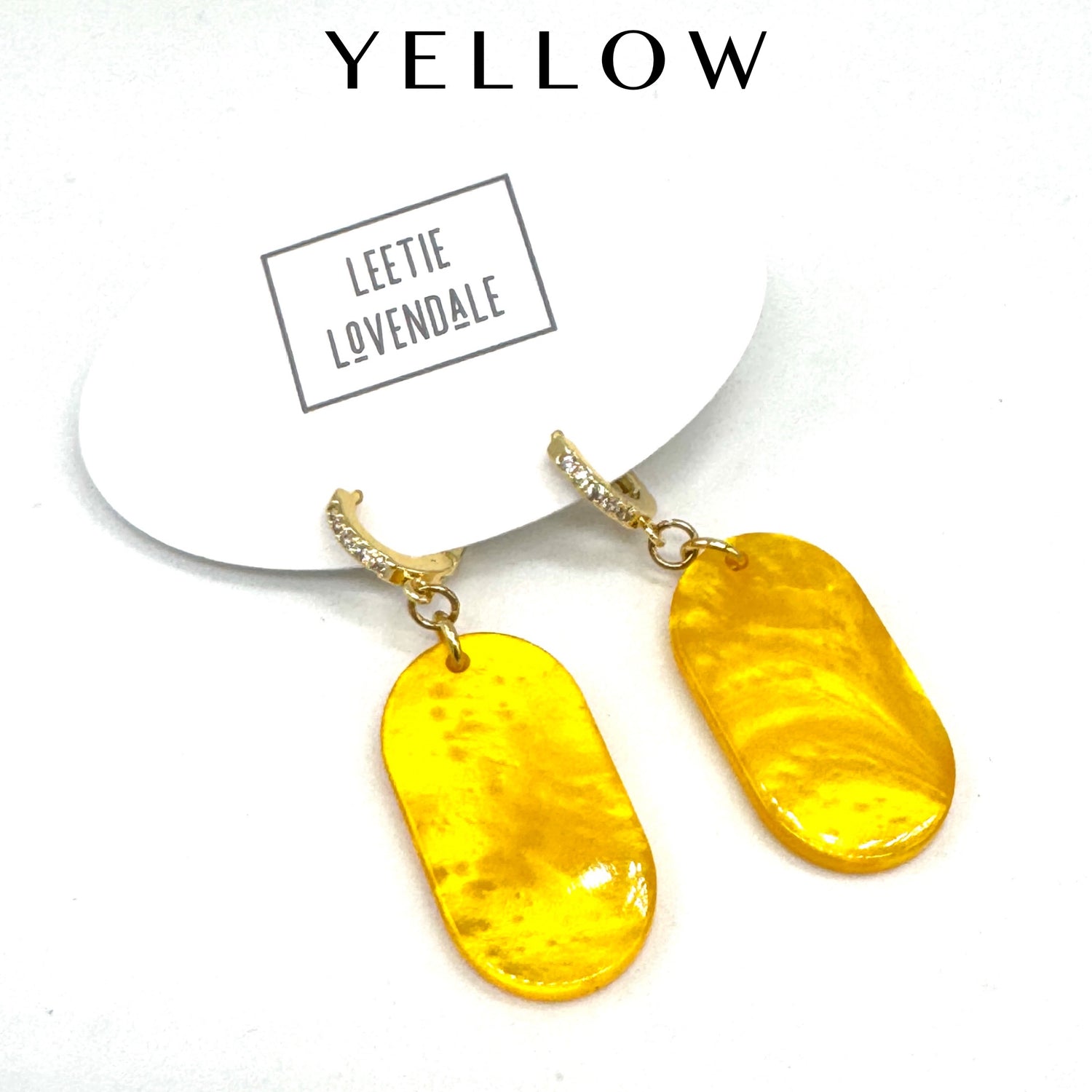 Yellow earrings with gold hooks on a white background, featuring the brand &