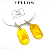 Yellow earrings with gold hooks on a white background, featuring the brand &