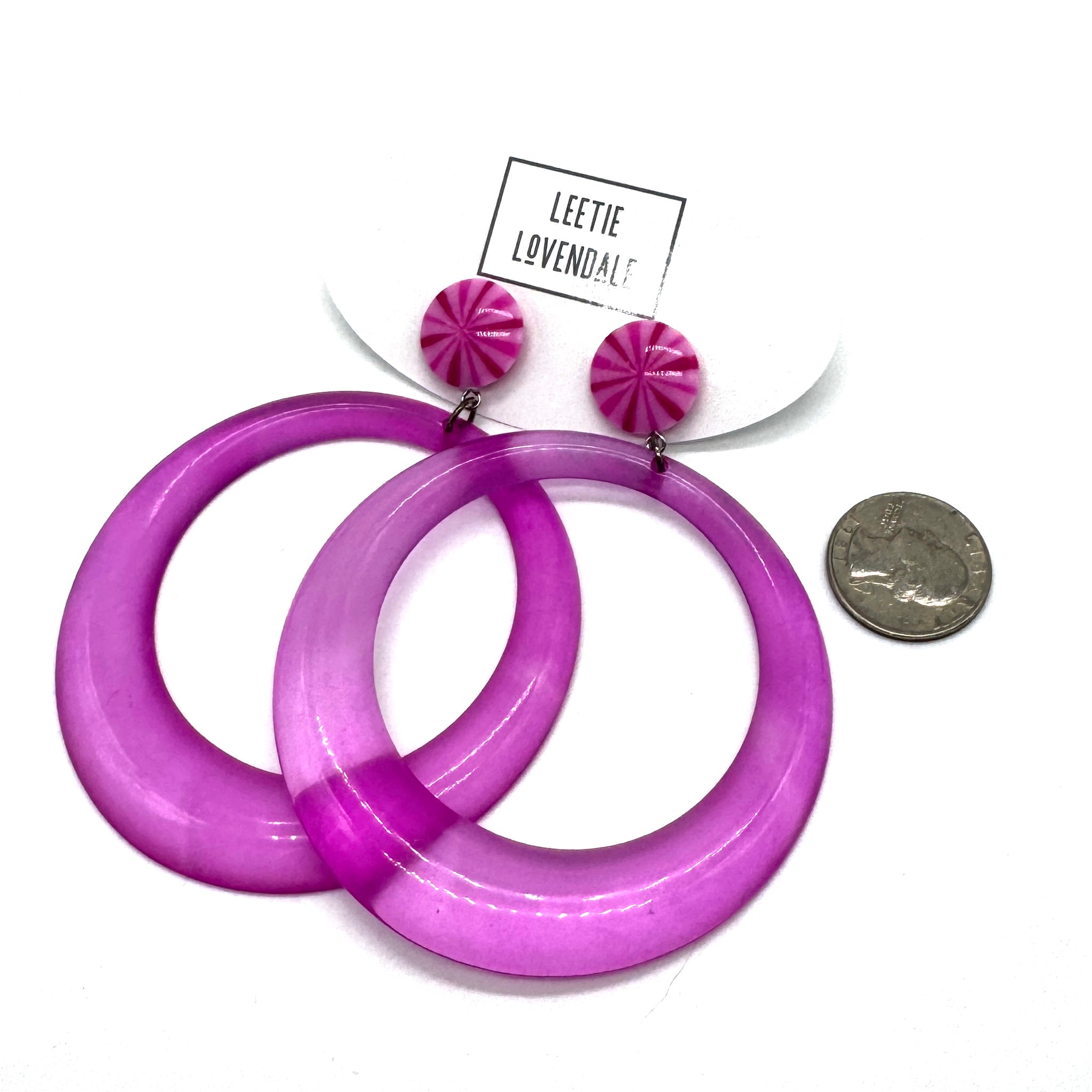 Purple hoop earrings with pink top parts on a white background, Leetie Lovendale brand visible.