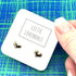 Silver heart stud earrings on a white branded card with a blue and green background.