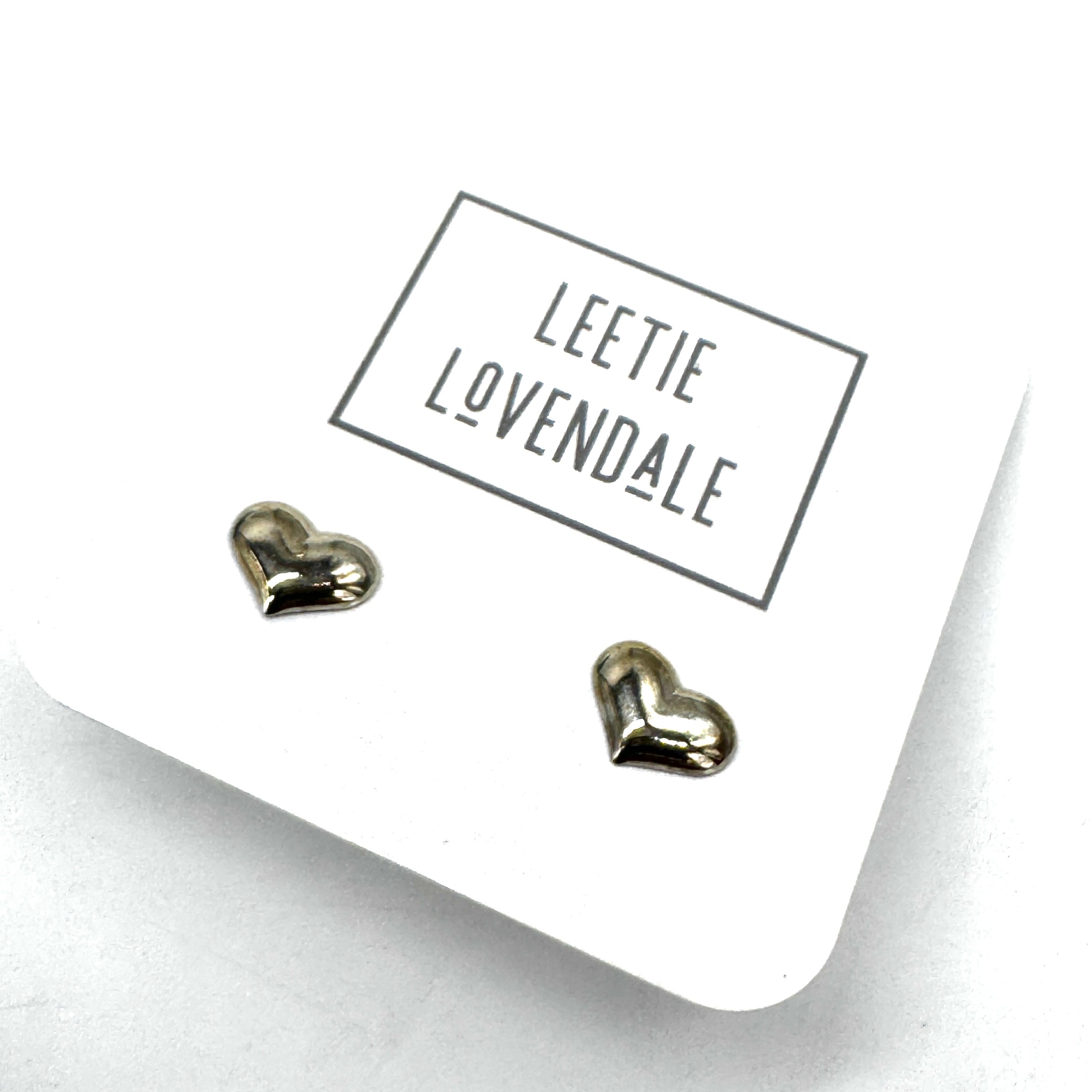 Heart-shaped earrings on a white card with &