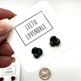 Green flower-shaped earrings on a card with &