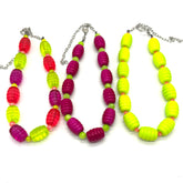 Colorful beaded necklaces with red, green, and purple beads on a white background.