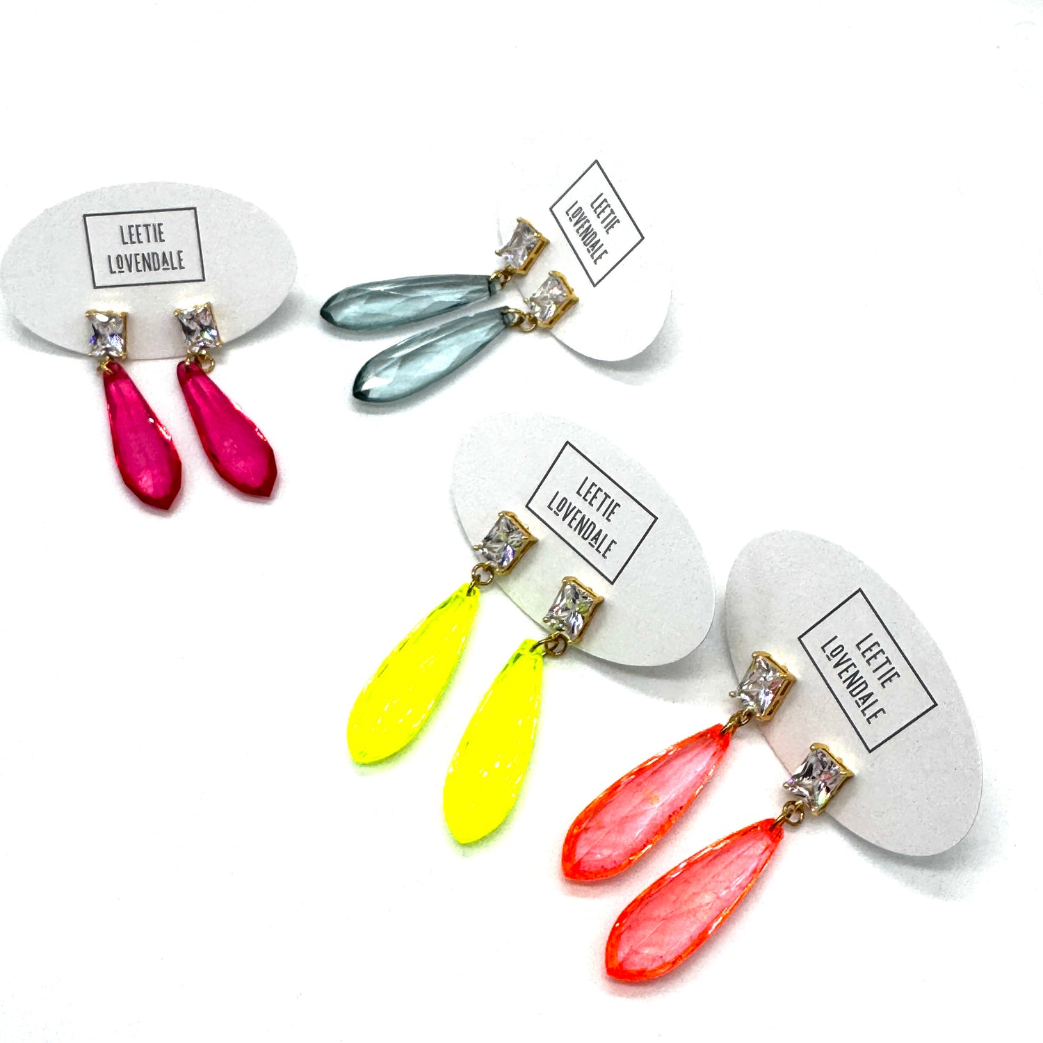Colorful teardrop earrings on white cards with &