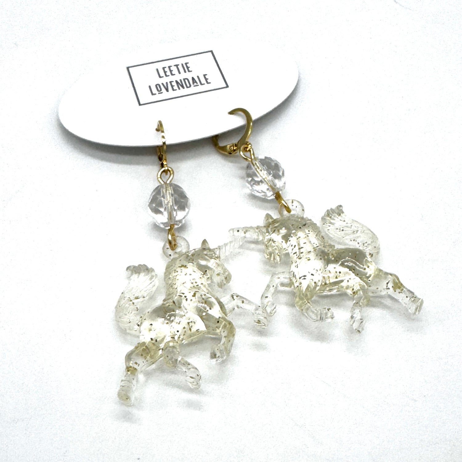 Crystal horse earrings on a white background with &