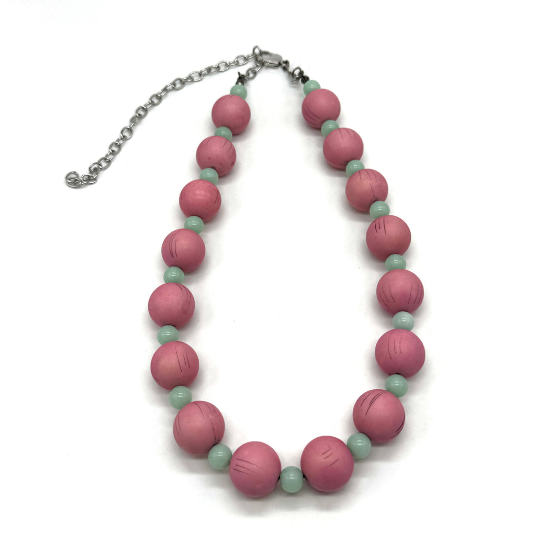 Necklace with pink and green beads on a white background