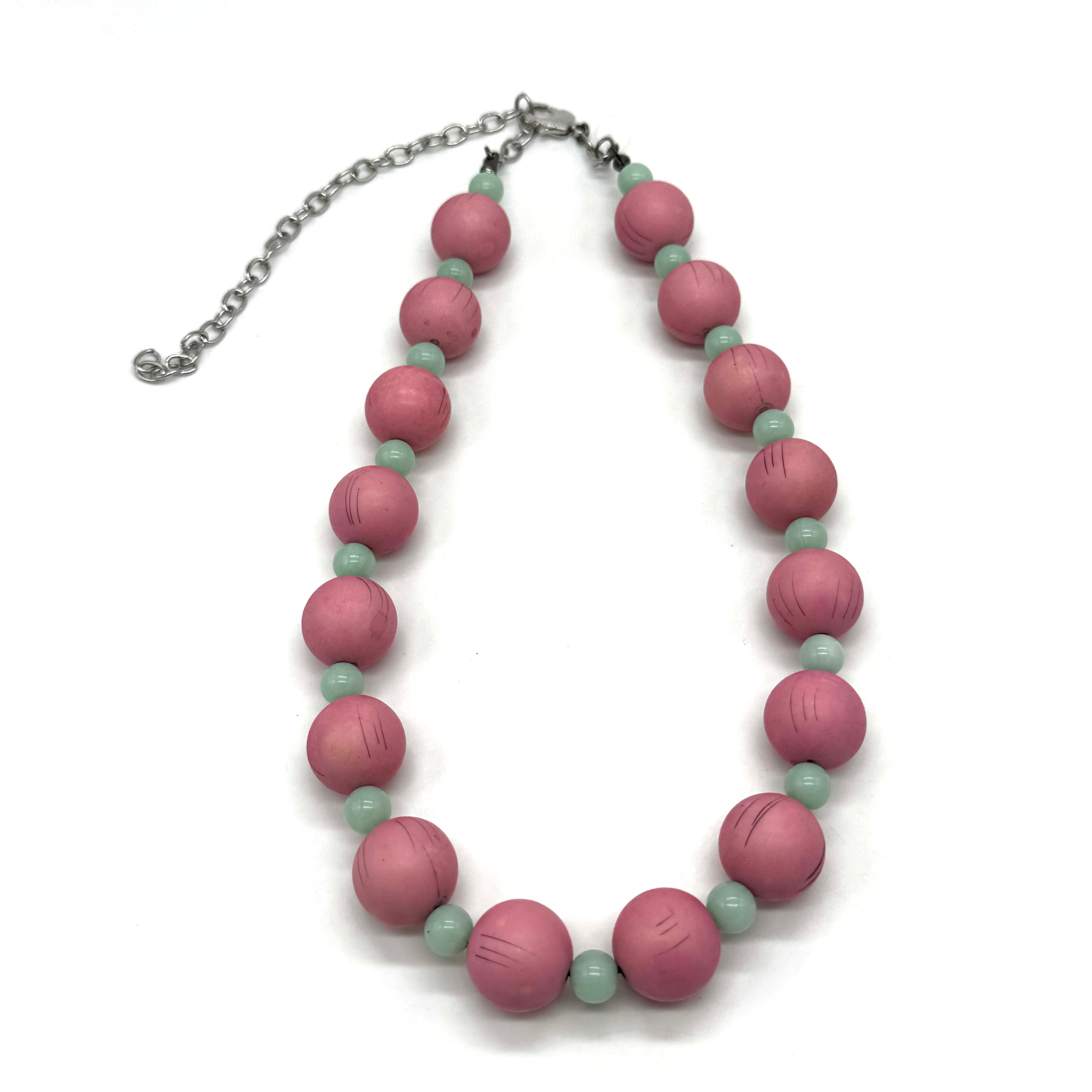 Necklace with pink and green beads on a white background