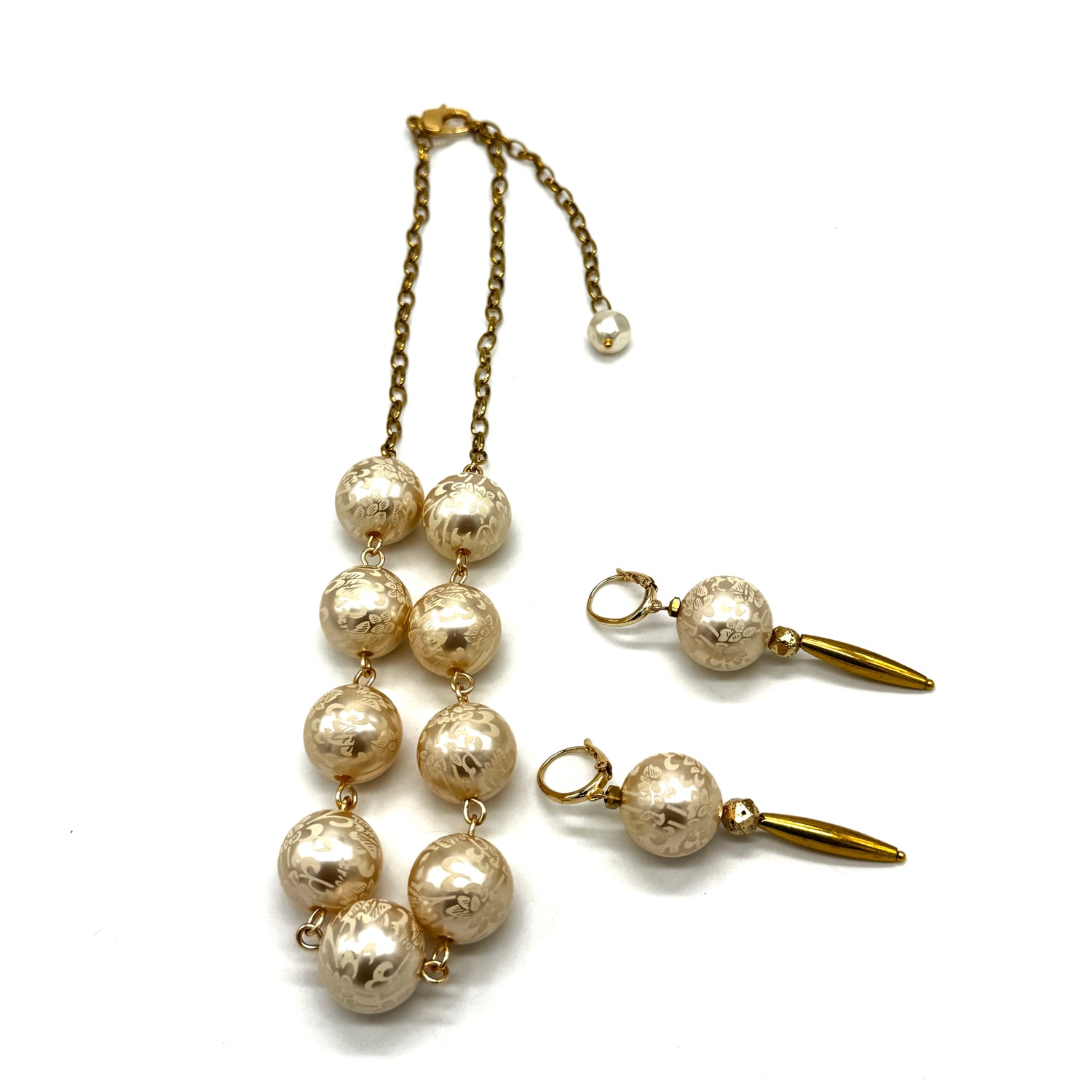 Half chain and half beaded necklace, featuring gold chain and floral etched pearl lucite beads, alongside matching dangle earrings.
