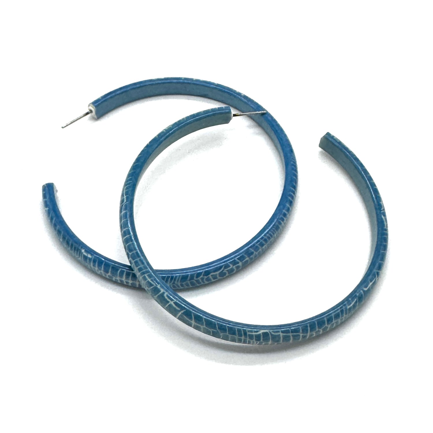 Large crackled blue lucite hoop earrings.