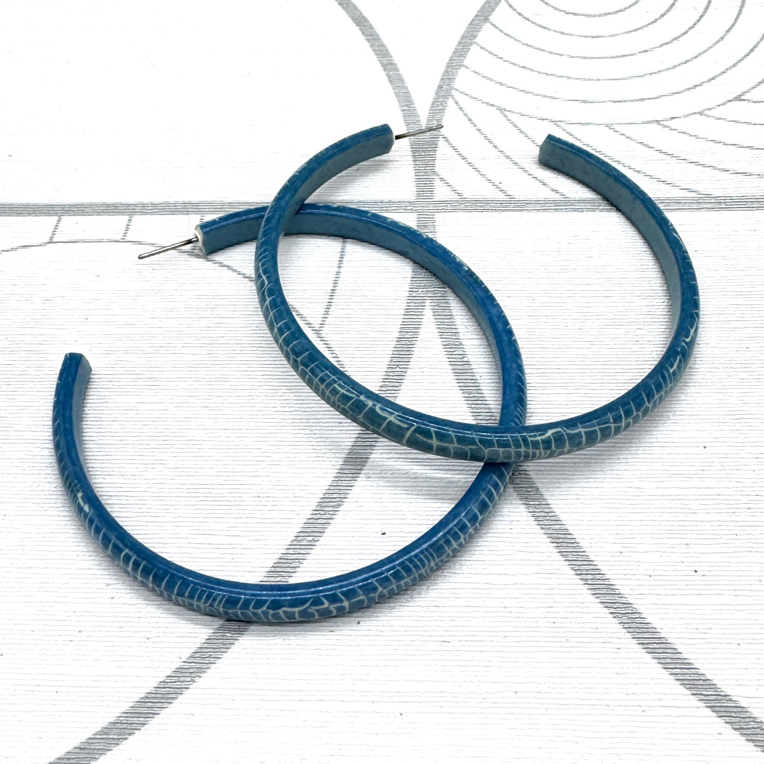 Large crackled blue lucite hoop earrings.
