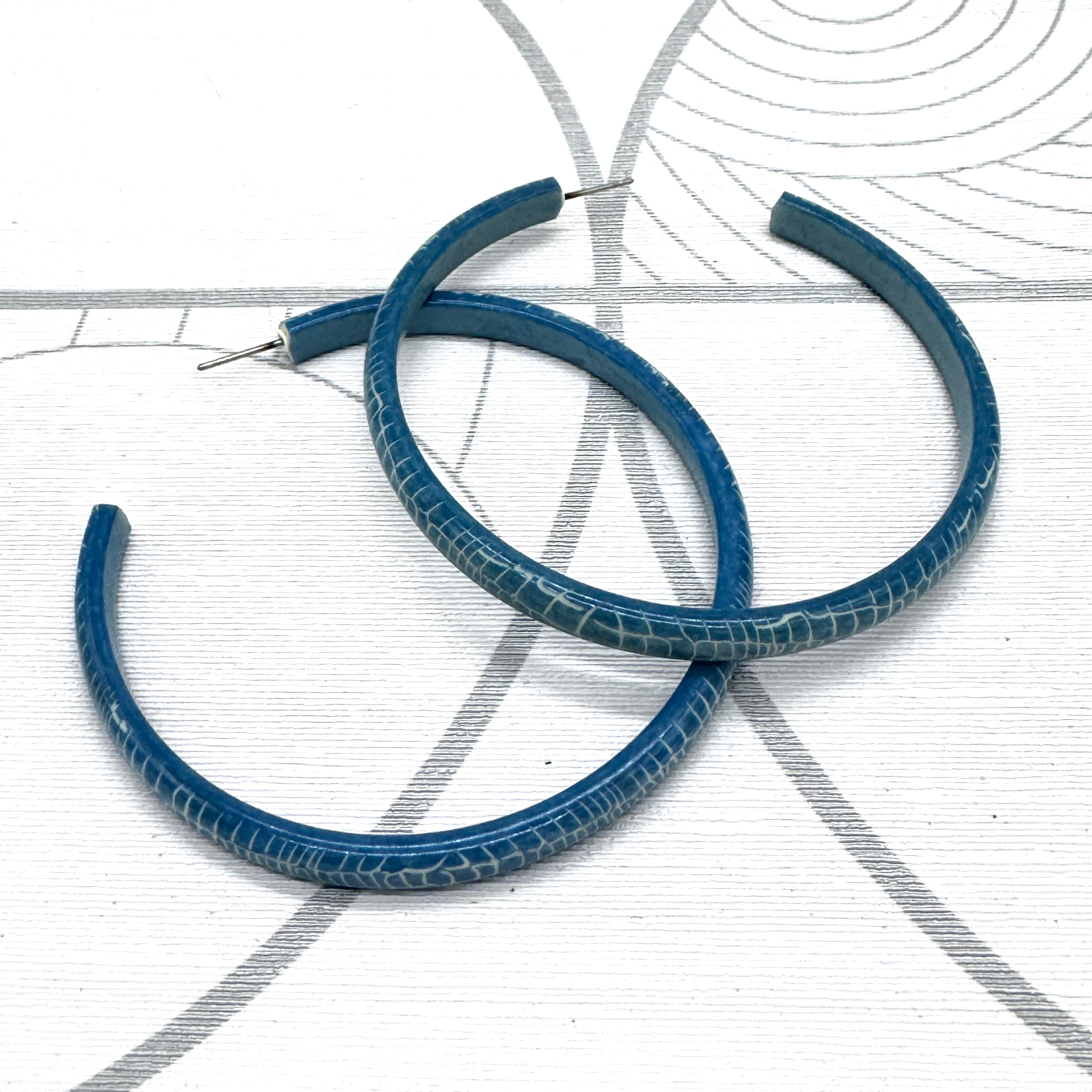 Large crackled blue lucite hoop earrings.
