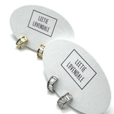 Silver and gold crystal hoop earrings on branded earring cards.