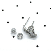 Silver and crystal hoop earrings on a polka dot background.