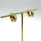 Gold hoop earrings with a crystal set in the center of each.