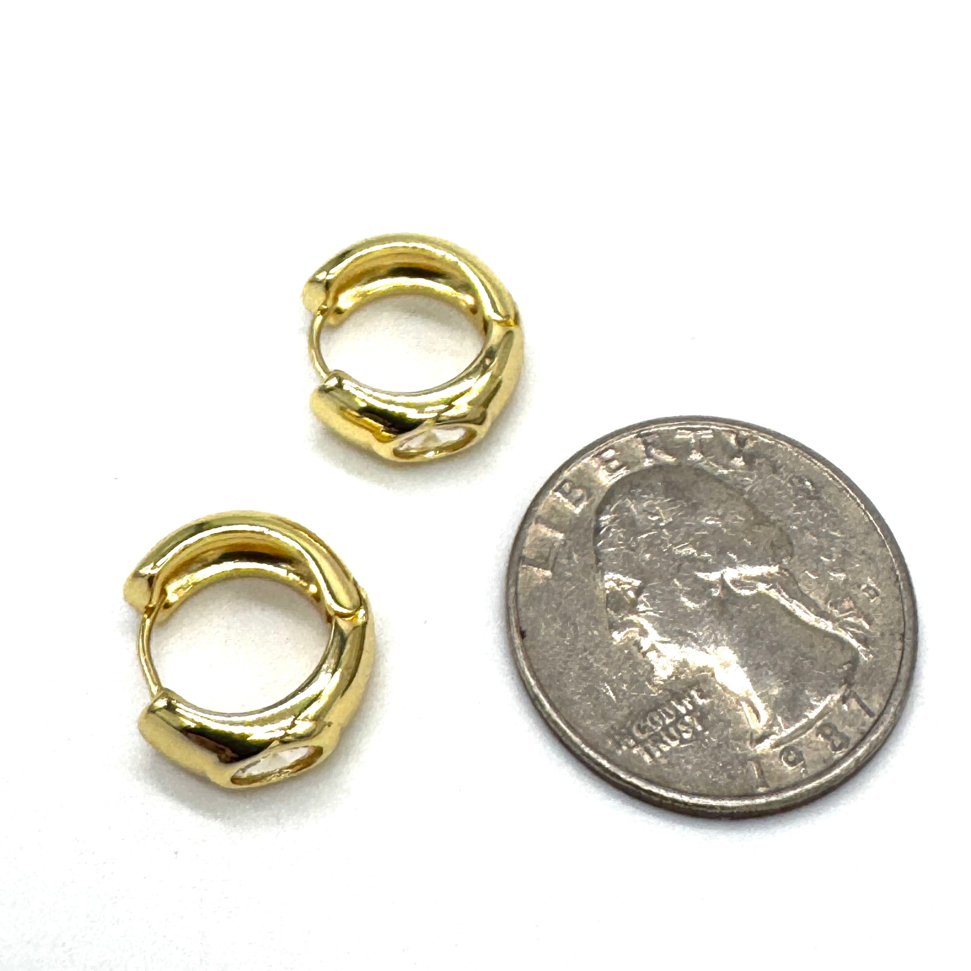Silver and crystal hoop earrings  with a quarter for scale.