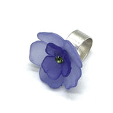 Perwinkle and purple floral cocktail ring on a white background.