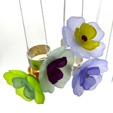 Four colorful floral cocktail rings on a white background.