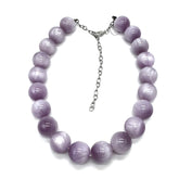 A beaded necklace made of smooth, round lavender-purple beads with a silver-tone chain extender clasp, displayed on a clean white background.