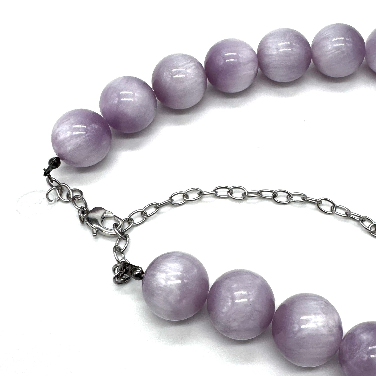 A beaded necklace with smooth, round lavender-purple beads and a silver-tone chain extender clasp, shown on a plain white background.